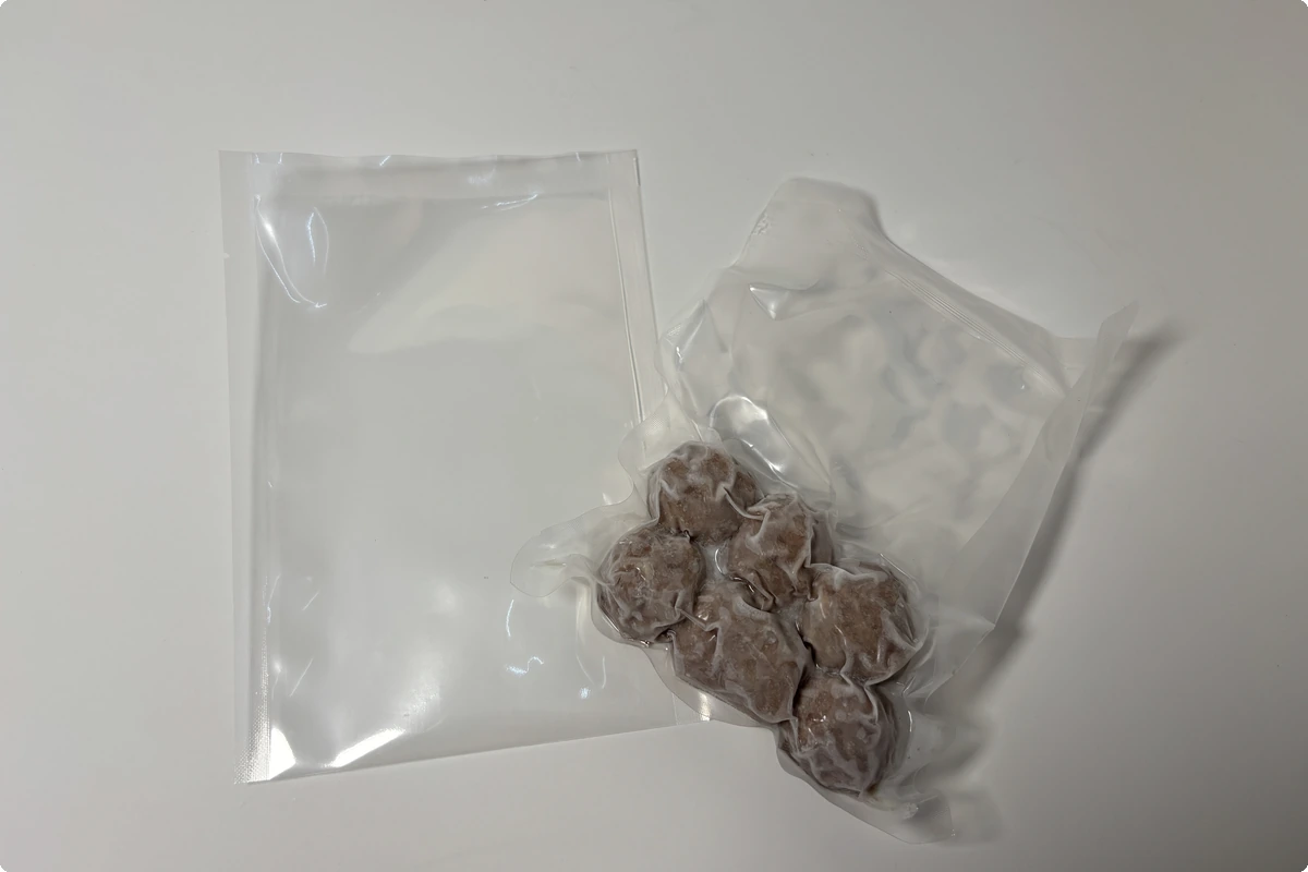 3-side seal vacuum pouch for frozen food — empty pouch beside vacuum-packed frozen beef meatballs, from DSS Pack