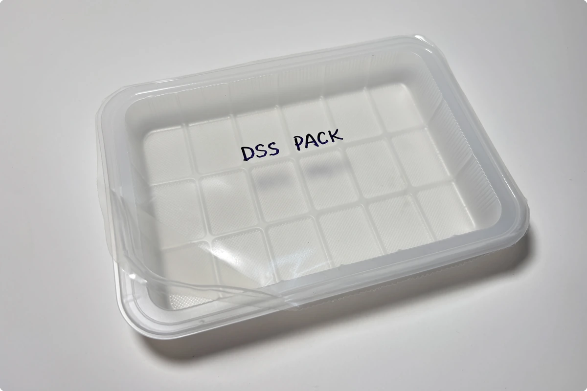 Peelable lidding film sealed onto a PE tray for frozen food — easy-peel lid film by DSS Pack, opening cleanly without tearing